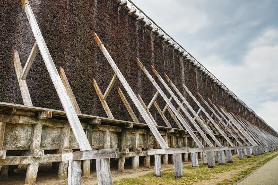 Historischer Gradierbau mit hölzernen Stützen unter bewölktem Himmel